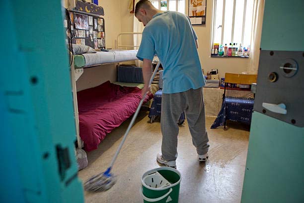 a young prisoner mopping the floor of his cell